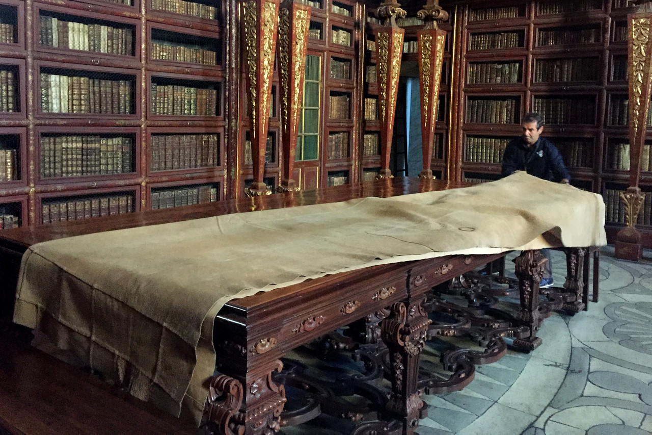 Interior barroco de la Biblioteca Joanina de la Universidad de Coímbra con estanterías doradas y libros antiguos